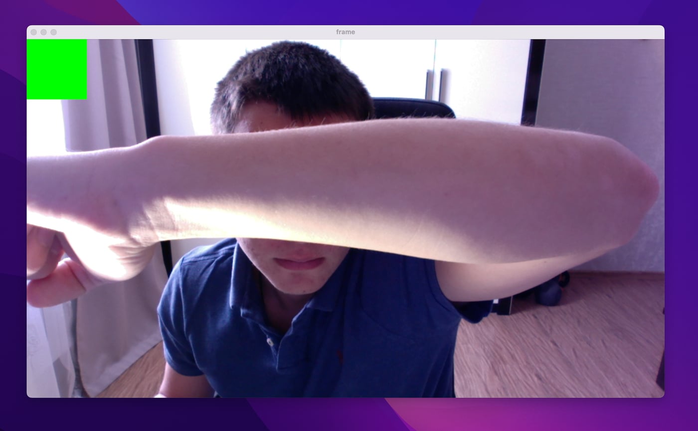 A forearm held up to the webcam, the rectangle still green